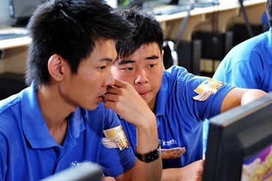 山西新华参赛选手李颜卓宇（左）跟队友讨论方案